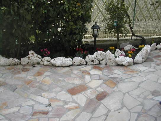 Flowerbed witk tumbled rocks in limestone